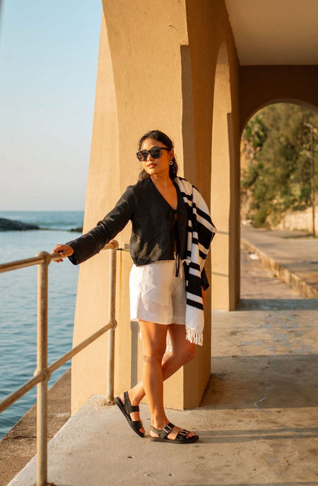 Woman standing by a waterfront with a scenic background