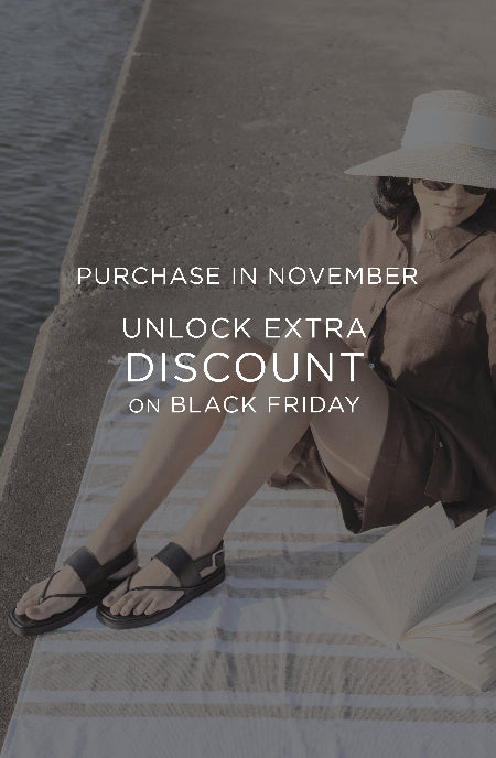 Woman sitting by a waterfront with promotional text overlay for an extra discount on Black Friday.